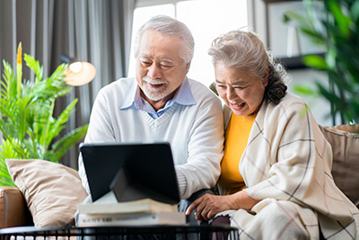 Elderly couple smiling at a computer screen